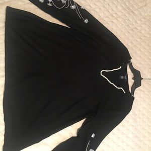 A  tunic sweater with flare sleeves and embroider